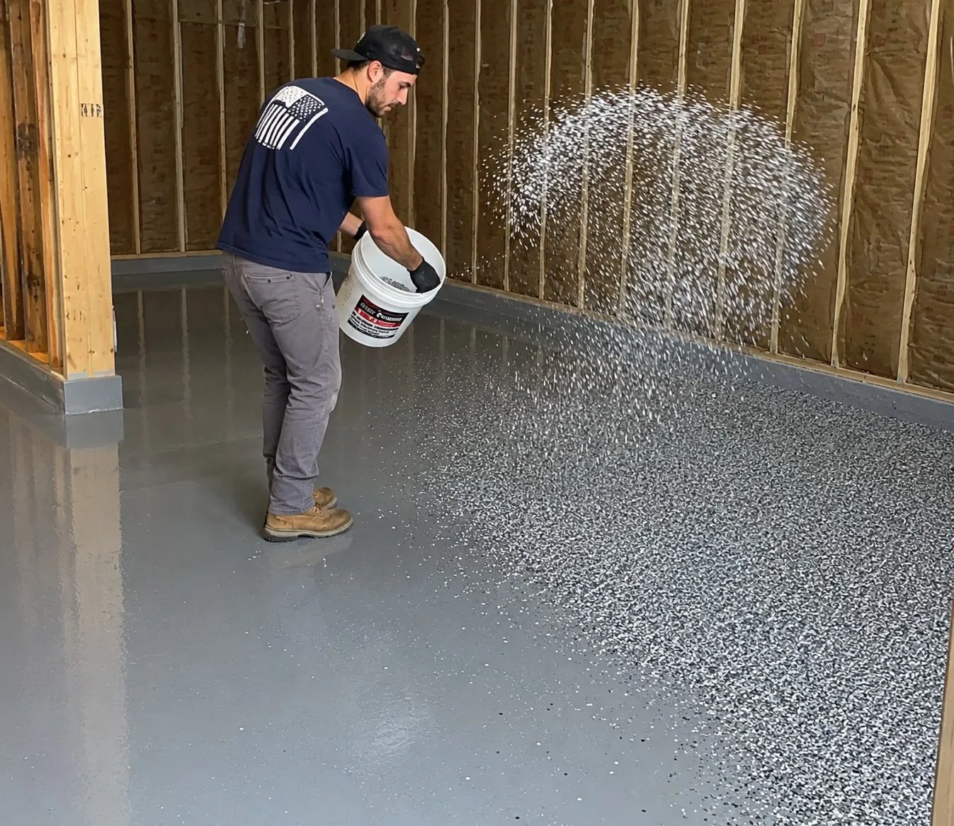 Crew broadcasting decorative flake during a garage floor install