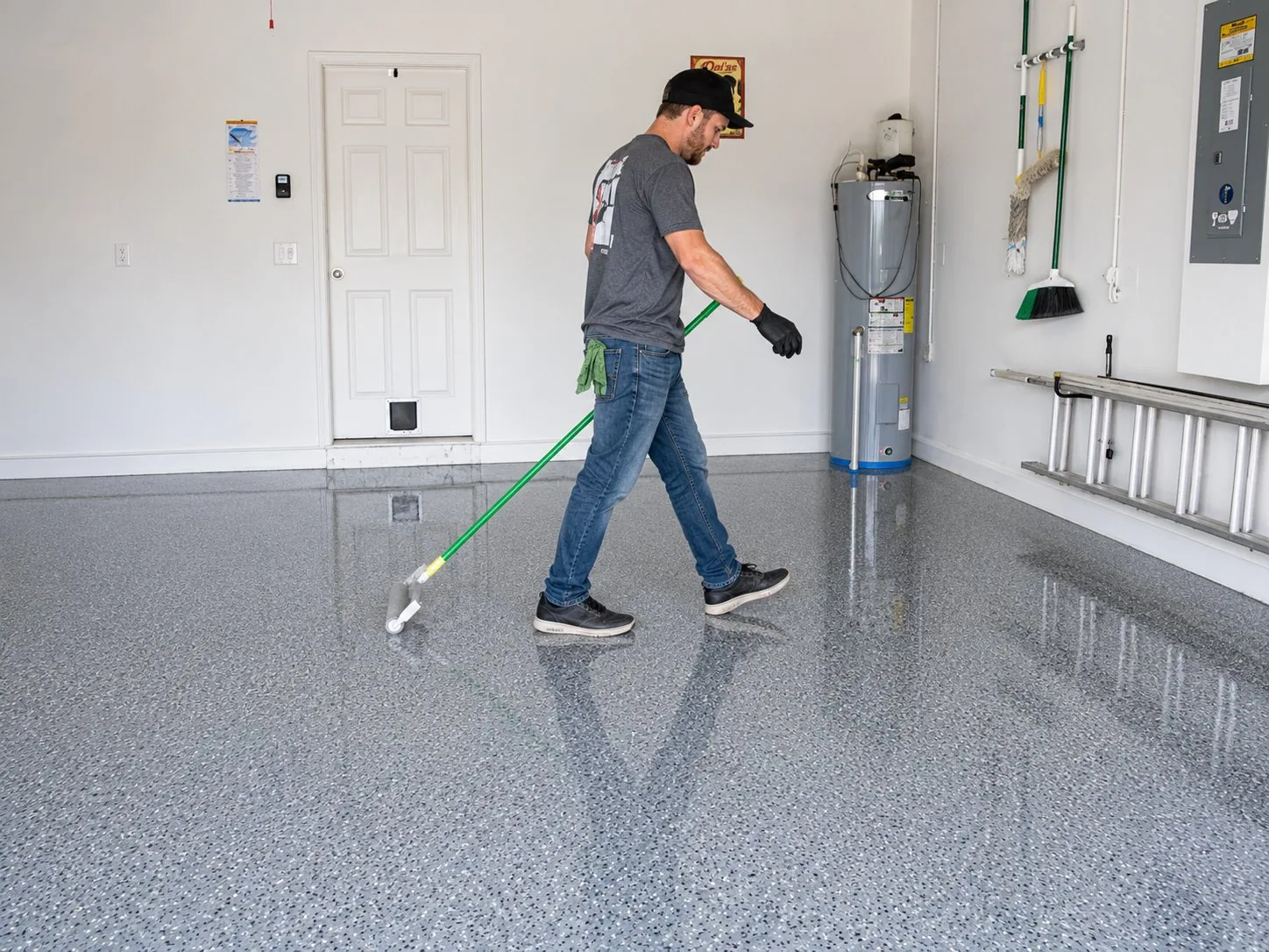 Rolling UV-stable polyaspartic topcoat onto a flake garage floor